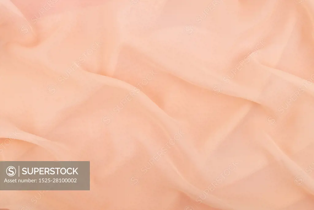 Peach coral soft chiffon fabric texture. Delicate folded cloth silk, organza, crepe chiffon background. Fashion elegant wedding background.