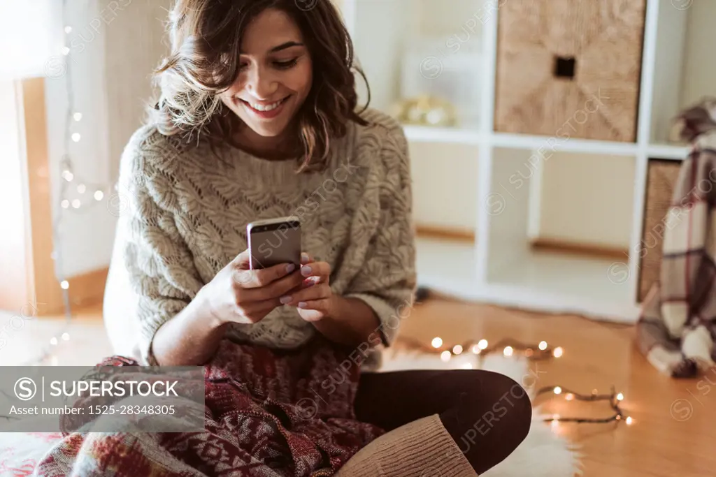 Woman texting in a smartphone - Christmas and Winter Season