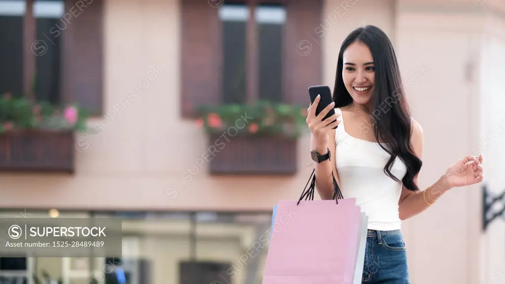 Happy beautiful asian woman with shopping bags enjoying in shopping. Lifestyle shopping and business concept.