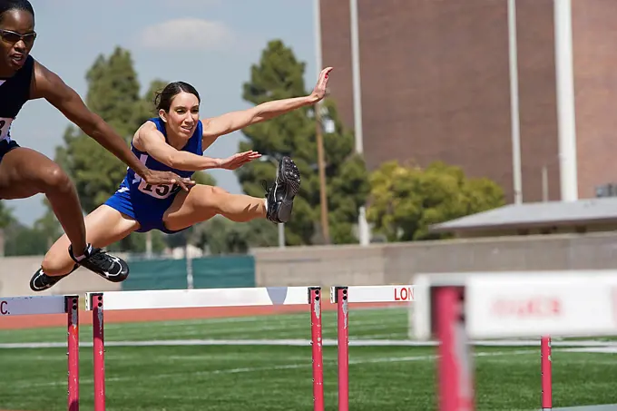 Female athletes hurdling