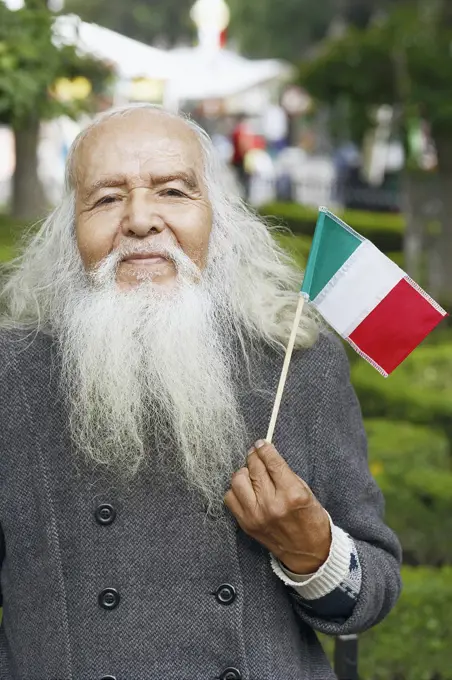 Portrait of a senior man holding a Mexican flag