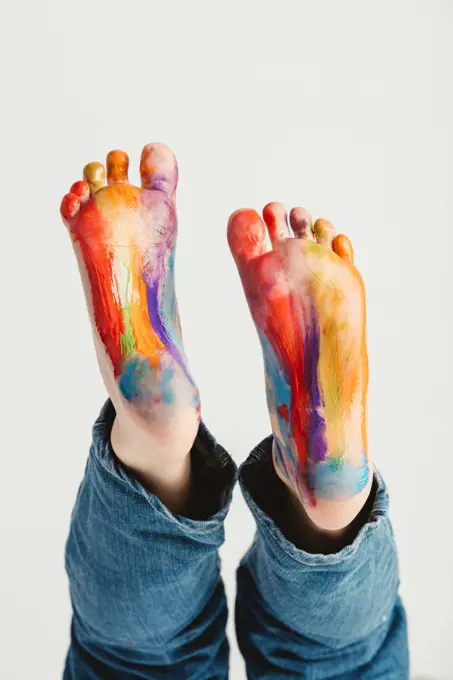 Kids feet painted in rainbow colors. Messy fun. Creative activity.. Kids feet painted in rainbow colors.