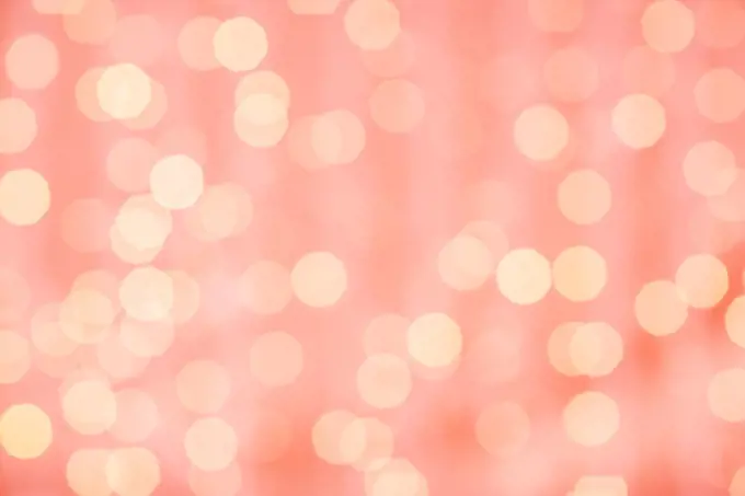 holidays and design concept - blurred bokeh lights in living coral, color of the year 2019. blurred bokeh lights in living coral color