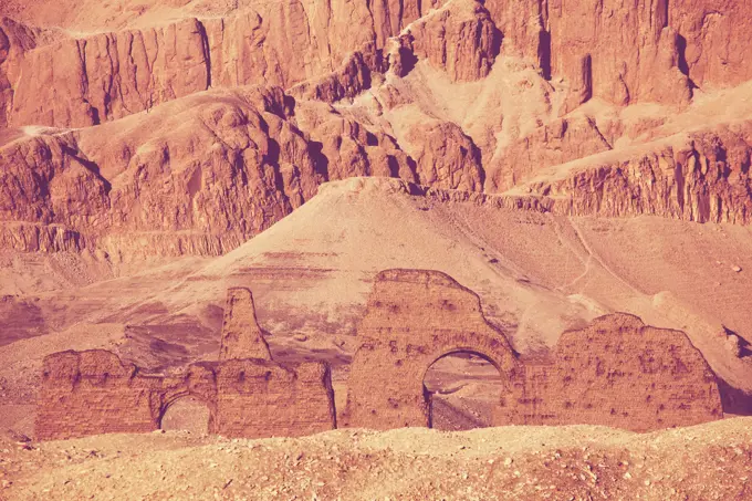 Unusual Egyptian landscapes. Dry mountains and anciend ruins toning in living coral color.