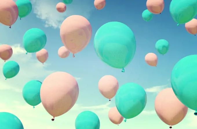 Colorful blue and pink balloons floating in summer holidays in pastel color filter, concept of summer, holidays, and joyful