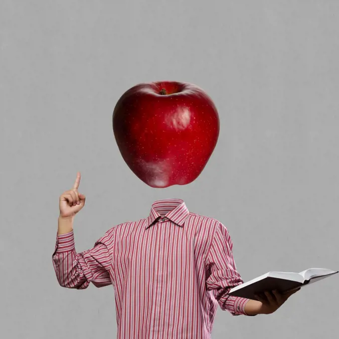 Great mind. Businessman with book in hand and apple instead of head