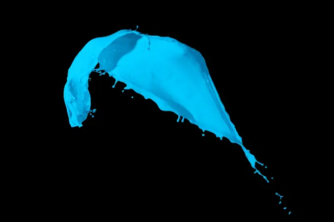 Colored paint splash. Picture of blue paint splashing isolated on black