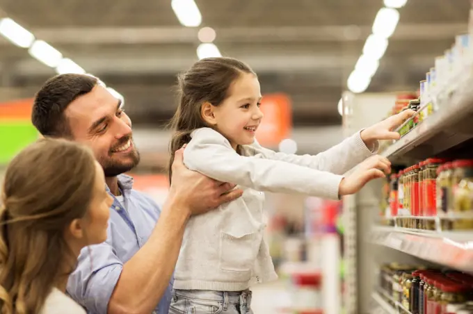 sale, shopping, consumerism and people concept - happy family with child buying food at grocery store or supermarket