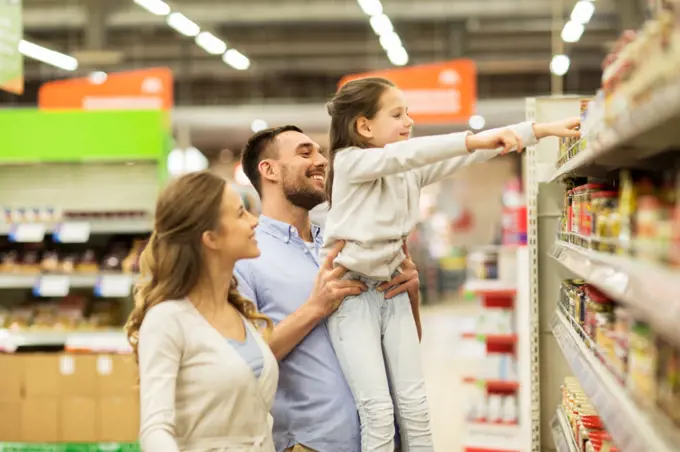 sale, shopping, consumerism and people concept - happy family with child buying food at grocery store or supermarket