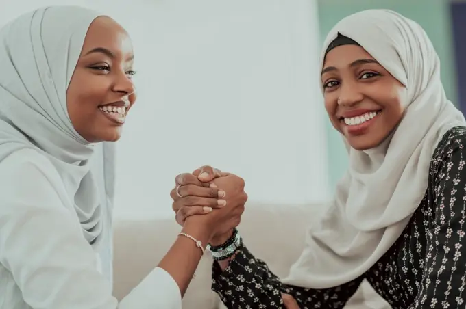 African women arm wrestling conflict concept, disagreement, and confrontation wearing traditional Islamic hijab clothes. Selective focus. High-quality photo. African woman arm wrestling conflict concept, disagreement and confrontation wearing traditional islamic hijab clothes. Selective focus 