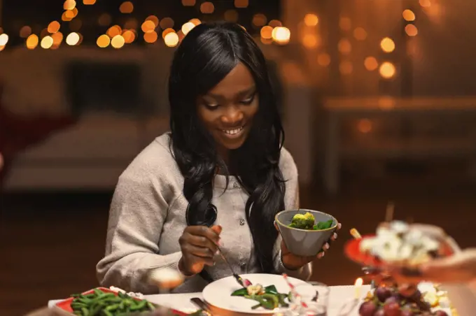 holidays, party and celebration concept - happy woman having christmas dinner and eating at home. happy woman having christmas dinner at home