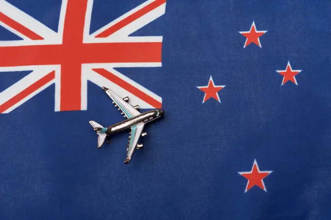 The plane over the flag of New Zealand, the concept of travel. Toy plane on the flag as a background.. The plane over the flag of New Zealand, the concept of travel.