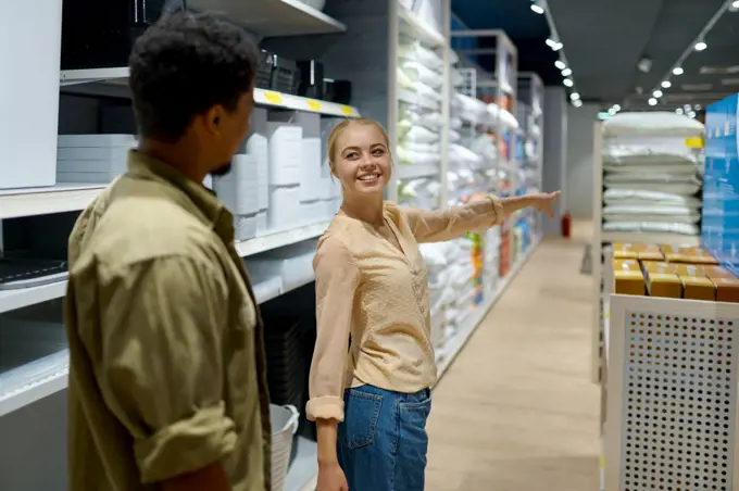 Beautiful couple buying household goods for home in store. Family shopping at supermarket. Happy couple buying household goods in store