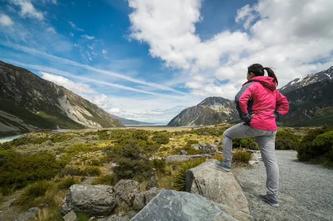 Woman traveller traveling in wilderness landscape of Mt Cook National Park. Mt Cook, the highest mountain in New Zealand,is known for scenic landscape, outdoor travel inspiration, mountain trekking.