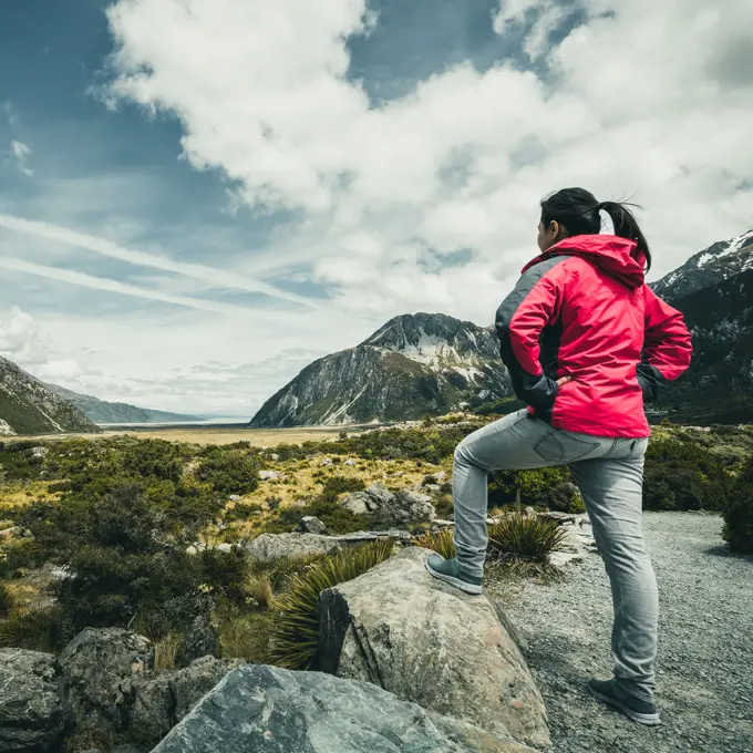 Woman traveller traveling in wilderness landscape of Mt Cook National Park. Mt Cook, the highest mountain in New Zealand,is known for scenic landscape, outdoor travel inspiration, mountain trekking.