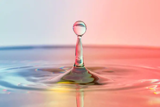 High speed water drop photograph, pillar with blue, red and yellow colors. High speed water drop photograph with blue and red colors