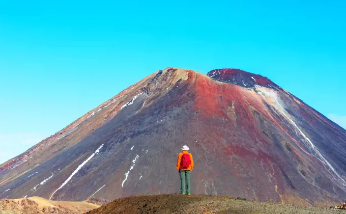 Man walking on hike trail route with New Zealand volcano,  Tramping, hiking, travel in New Zealand.