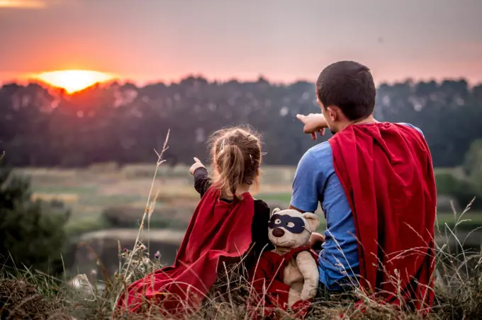 little girl with dad dressed in super heroes, happy loving family, father and daughter playing outdoors, family values. little girl with dad dressed in super heroes, happy loving family