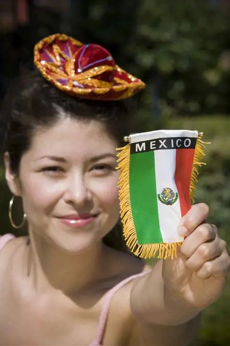 Young woman holding up Mexican flag