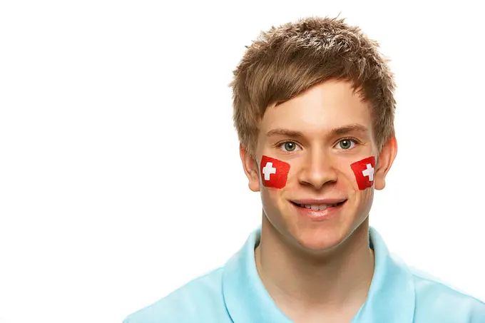 Young Male Sports Fan With Swiss Flag Painted On Face