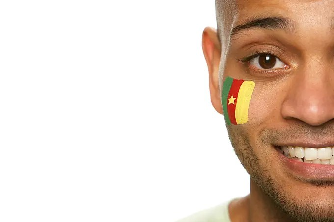 Young Male Sports Fan With Cameroon Flag Painted On Face