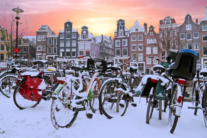 Snowy bikes in Amsterdam the Netherlands at sunset