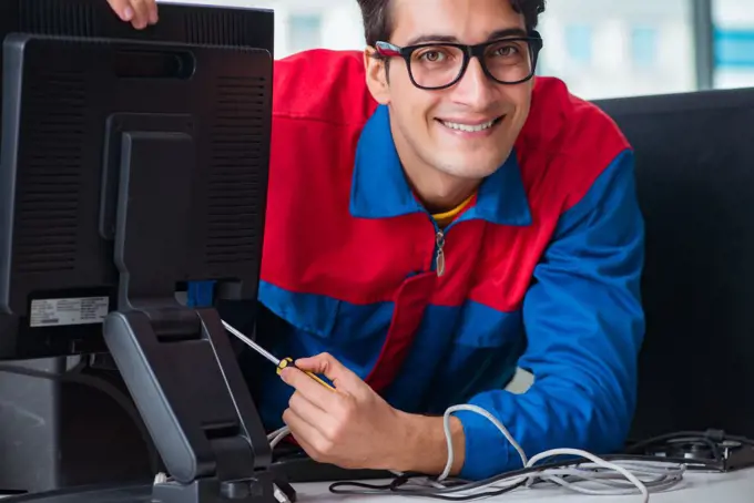 Computer repairman working on repairing computer in IT workshop. The computer repairman working on repairing computer in it workshop