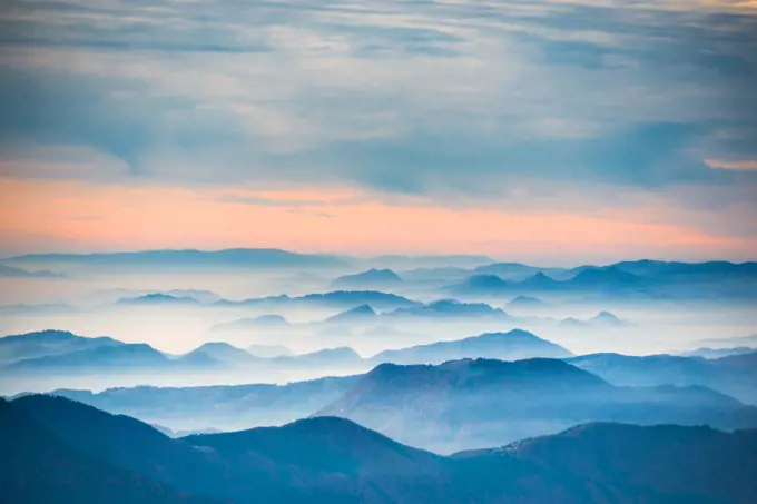 Sunset in the mountains. Dramatic colorful clouds over blue hills