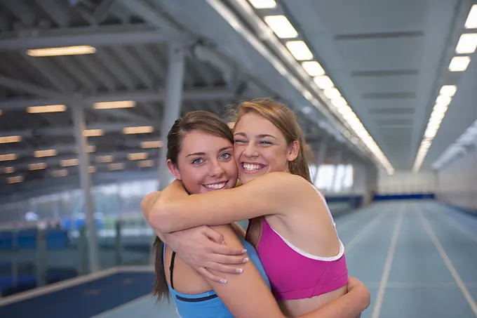 2 female athletes embracing