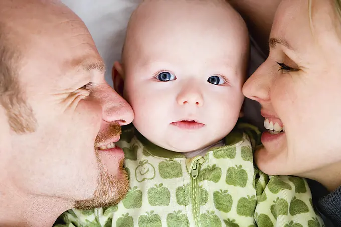 Baby laying between dad and mom