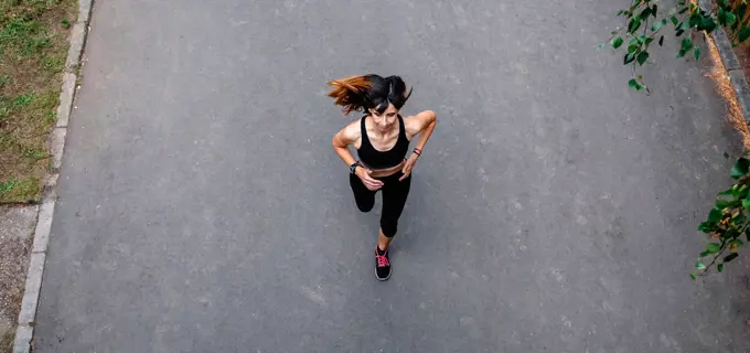 Aerial view of female athlete running on a road