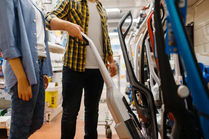 Male person hand holds vacuum cleaner in electronics store. Man buying home electrical appliances in market. Male hand holds vacuum cleaner, electronics store