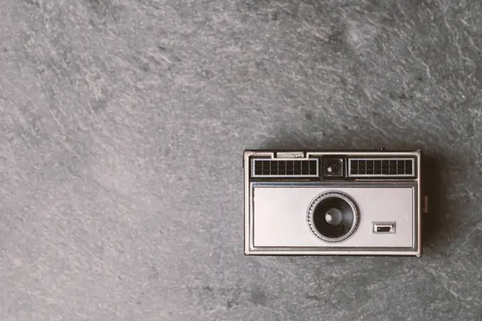 Retro classic 35mm photo camera on gray stone Background