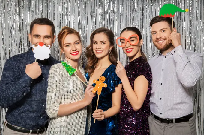 celebration, christmas and holiday concept - happy friends posing with party props. happy friends posing with christmas party props