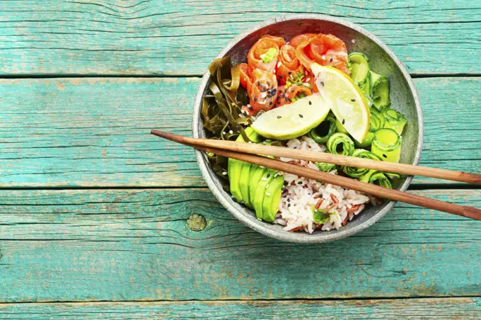 Hawaiian salmon poke bowl with rice,seaweed and avocado. Hawaiian poke bowl