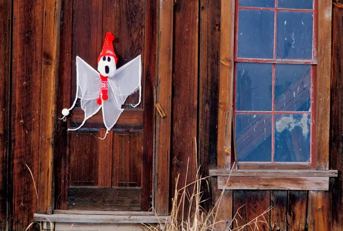 Halloween ghost decoration on wooden door of old-fashioned house