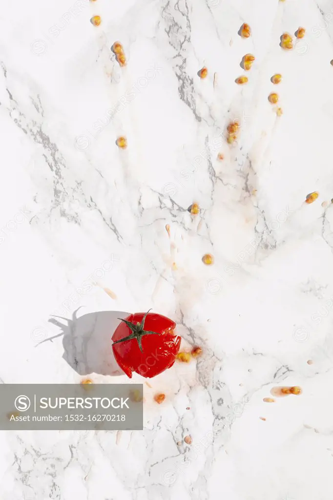 A splattered tomato on a marble surface