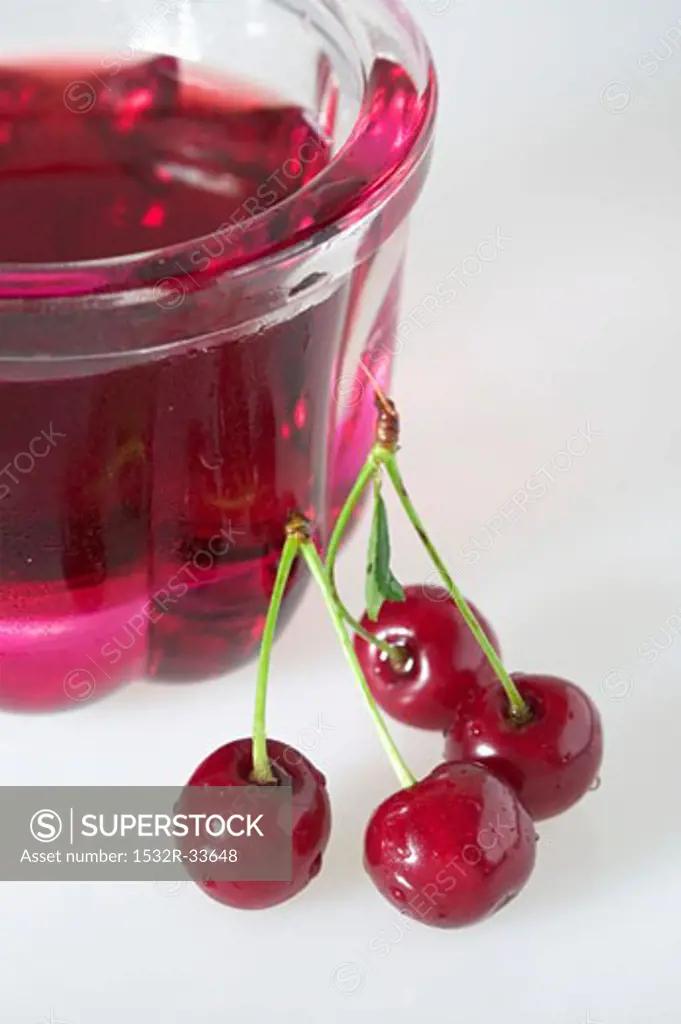 Cherry jelly in small jelly mould, fresh cherries beside it