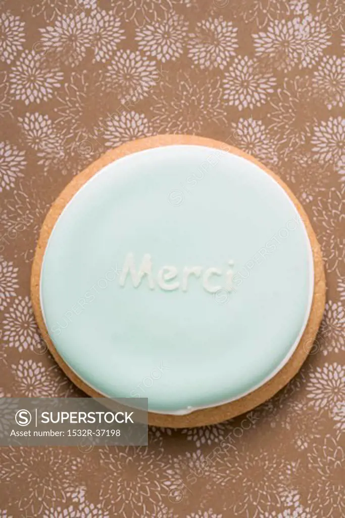 A pastel-coloured biscuit with the word 'Merci'