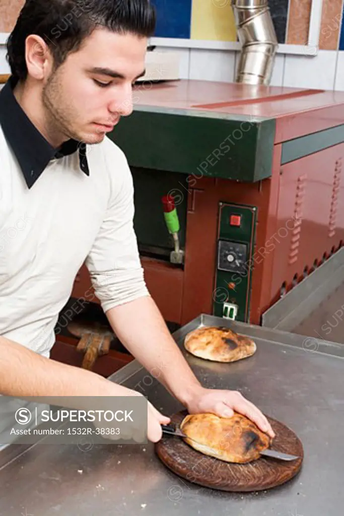 Young chef cutting pita bread