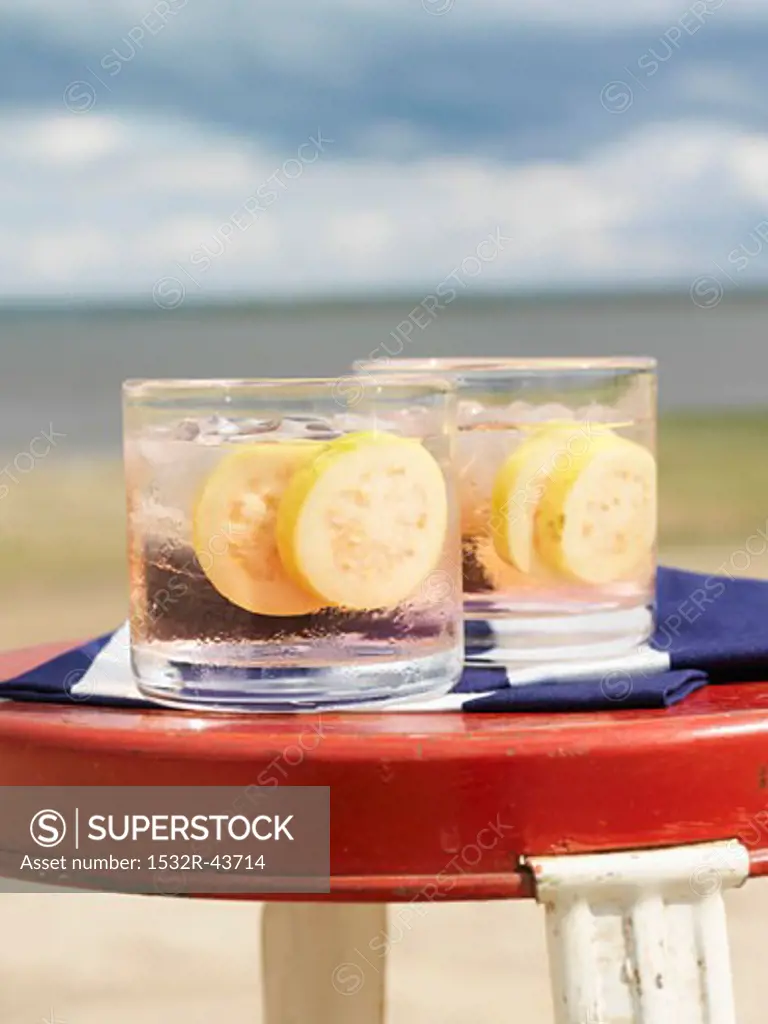 Afterglow cocktail with slices of guava on the beach