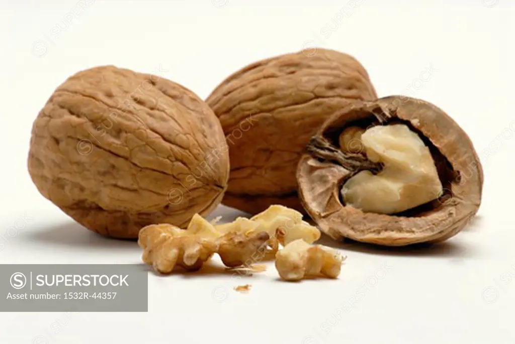 Two unshelled walnuts and one opened walnut