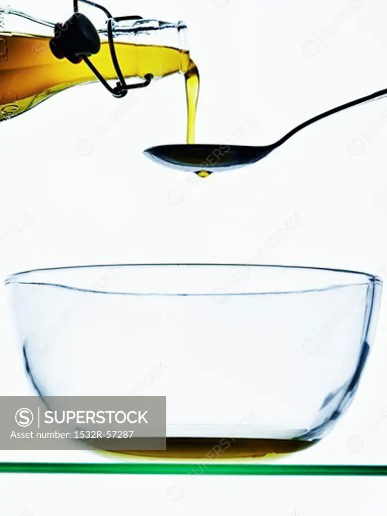 Olive oil being poured onto a spoon