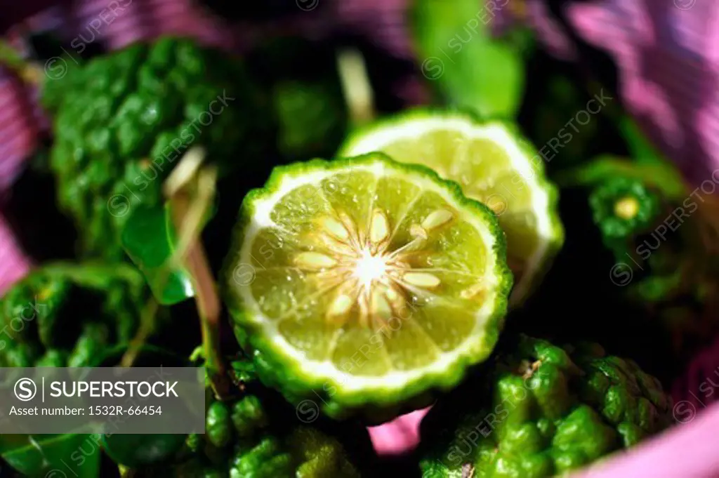 Thai limes with wrinkled skin, whole and halved