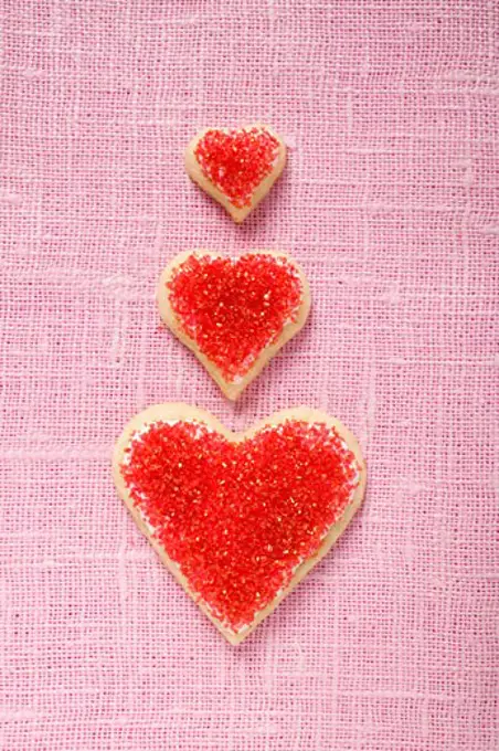 Three heart-shaped biscuits with red sugar