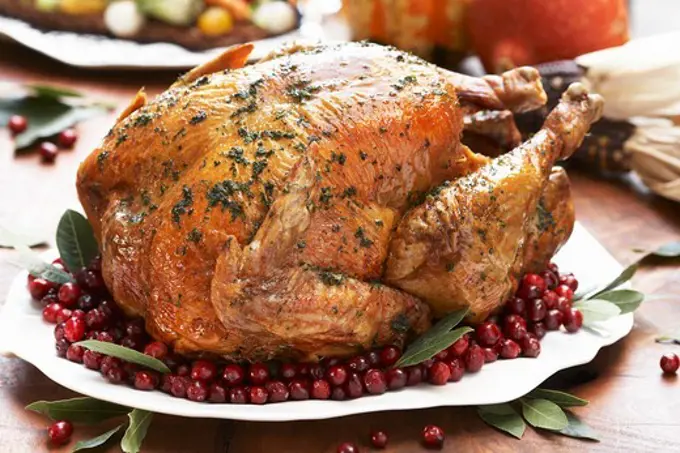 Whole Roast Turkey on a Platter with Cranberries and Bay Leaves