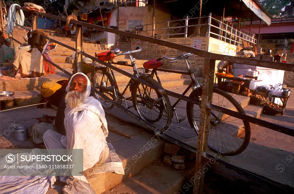 Old man sitting near the holy river ganga in the oldest Indian city of India , Banaras now Varanasi , Uttar Pradesh , India