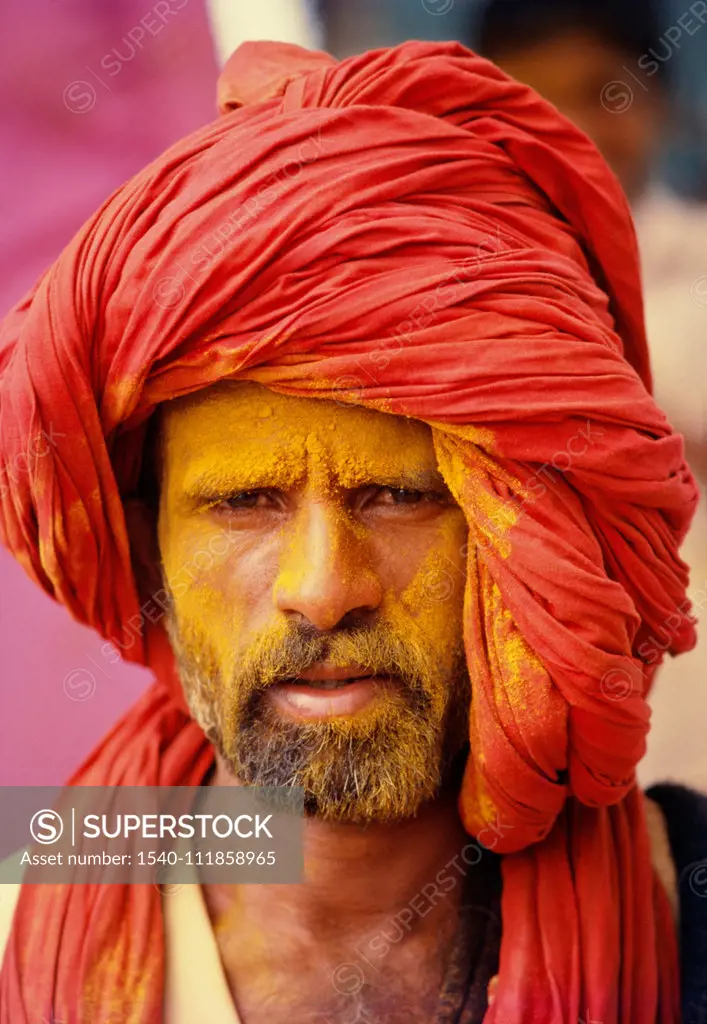 Khandoba's devotee with face smeared with yellow turmeric powder , Jejuri , Maharashtra , India