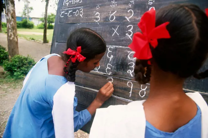 Rural school , girl writing on blackboard , Dehra Dun , Uttaranchal , India