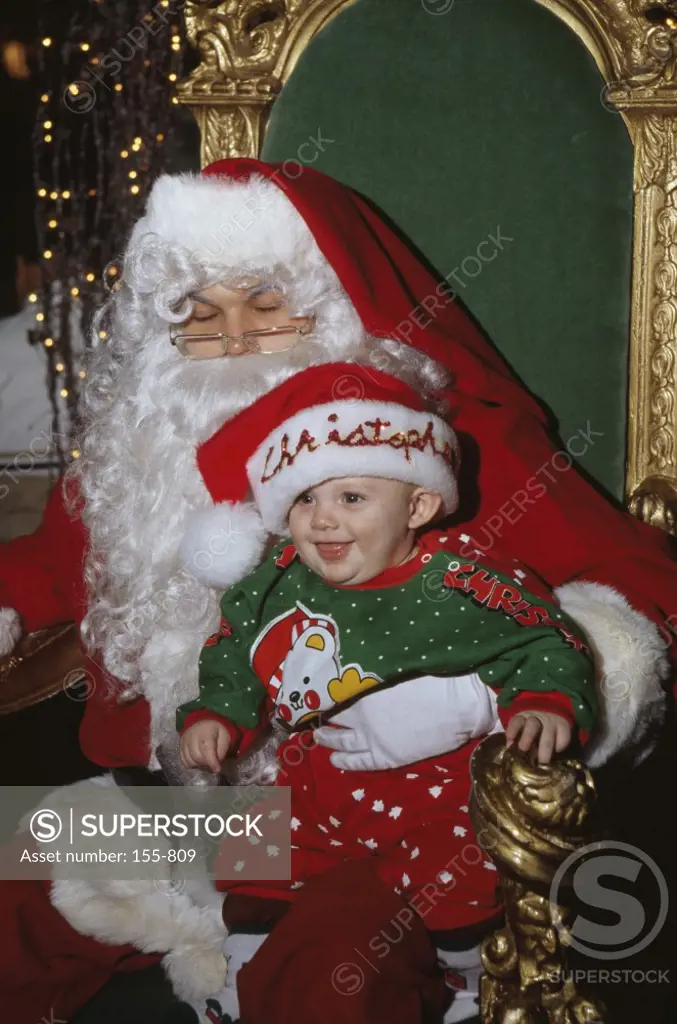 Santa Claus with a baby boy sitting in his lap